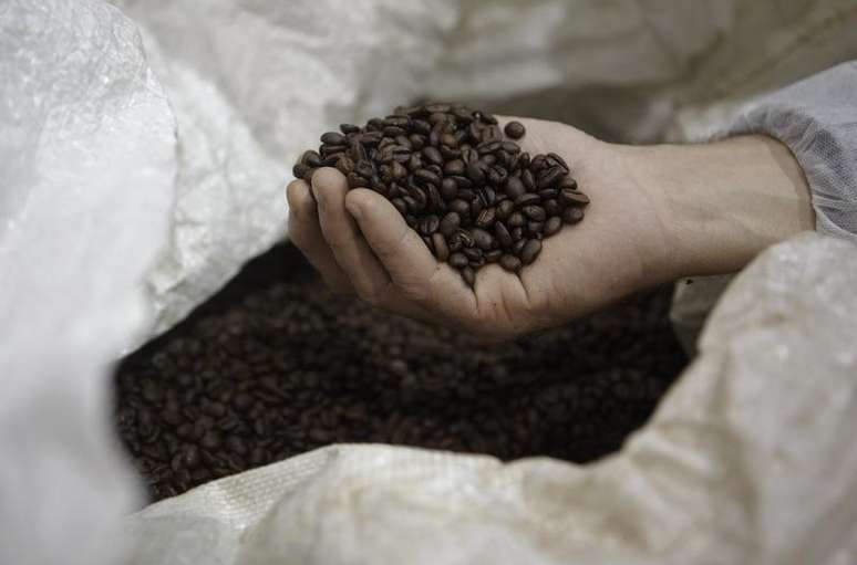 Homem segura grãos de café em Ville-la-Grand, na França  20/03/2013 REUTERS/Denis Balibouse