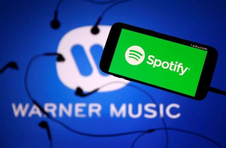 Foto ilustrativa mostra smartphone com logo do Spotify em frente a logo da Warner Music
24/7/2017 REUTERS/Dado Ruvic