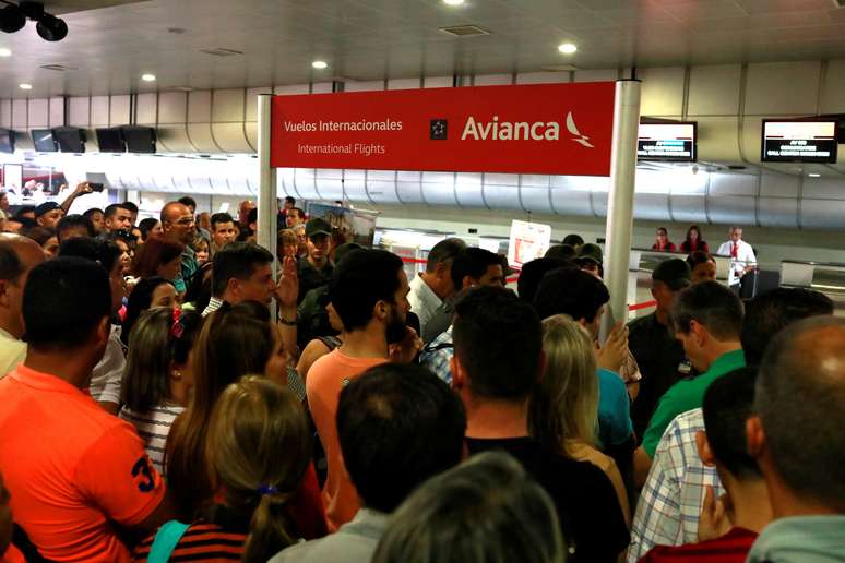 Passageiros se reúnem na frente dos balcões de check in da companhia aérea Avianca no aeroporto Simon Bolivar, em Caracas