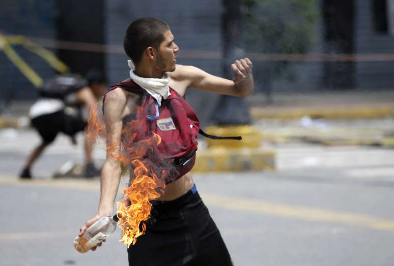 Manifestante atira coquetel molotov contra policiais das tropas do governo venezuelano