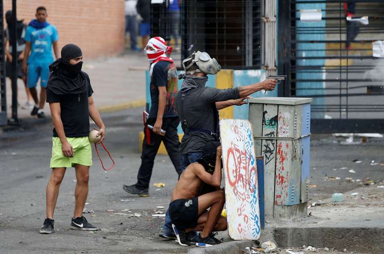 Manifestante armado enfrenta tropas do governo na Venezuela