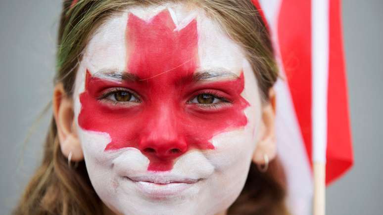 Garota com bandeira do Canadá pintada no rosto