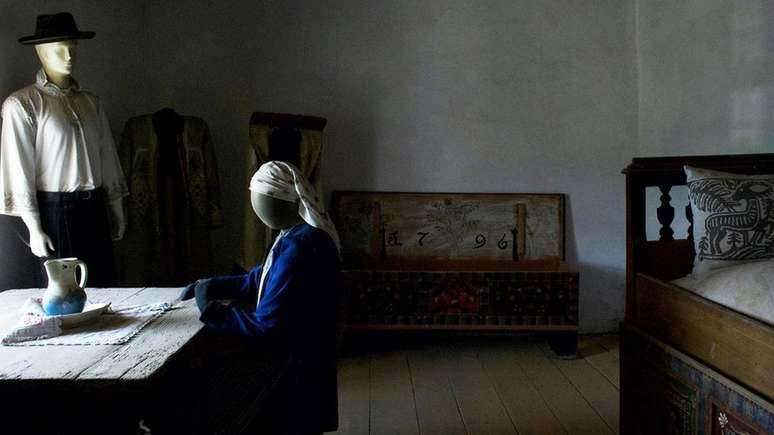 A pris&atilde;o tinha uma mesa, um ba&uacute; e uma cama de solteiro