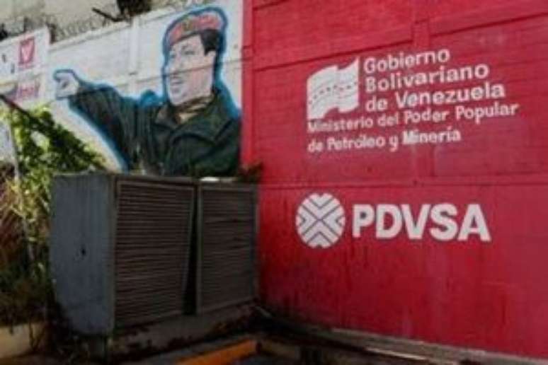 Logo da PDVSA pintado em muro ao lado de imagem do ex-presidente da Venezuela Hugo Chávez em Caracas 02/03/2017 REUTERS/Carlos Garcia Rawlins