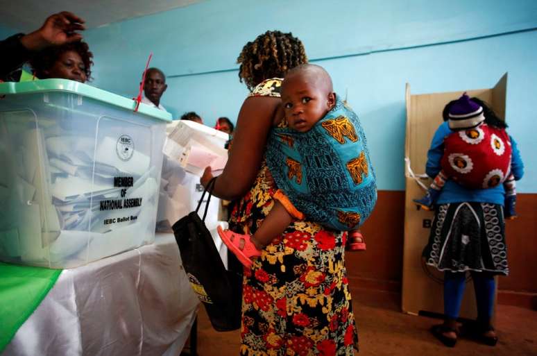 Mulher carregando bebê vota em seção eleitoral na cidade de Gatundu, no Quênia  REUTERS/Baz Ratner