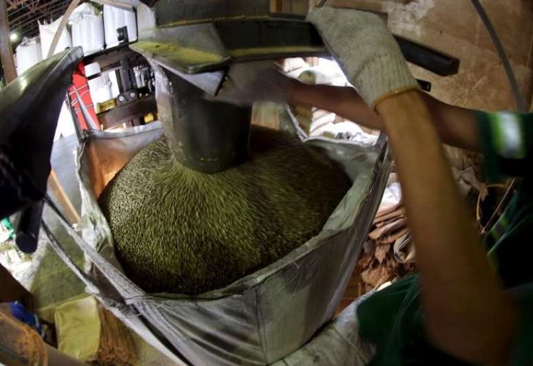 Funcionário preenche saco com grãos de café para exportação, em armazém em Santos 10/12/2015 REUTERS/Paulo Whitaker