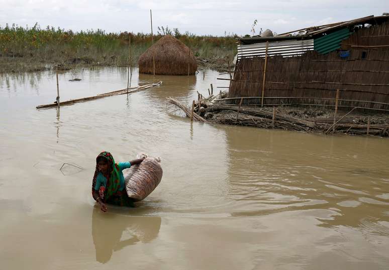 Mulher carrega pertences em área alagada em Gaibandha, Bangladesh 19/08/2017 REUTERS/Mohammad Ponir Hossain