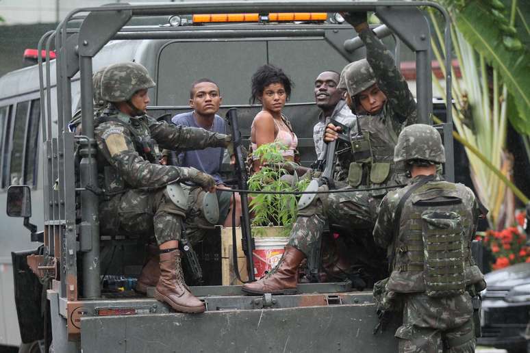 Cerca de 20 pessoas presas durante operação das Forças Armadas e polícias em sete comunidades da Zona Norte do Rio de Janeiro (RJ), chegam à Cidade da Polícia, na manhã desta segunda-feira (21).