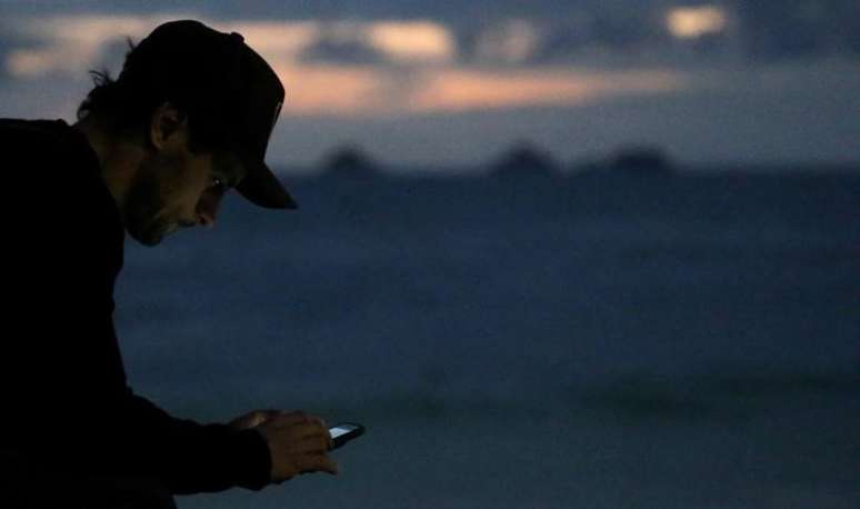 Homem usa o celular na Praia do Arpoador, Rio de Janeiro, Brasil
3/7/2017 REUTERS/Sergio Moraes