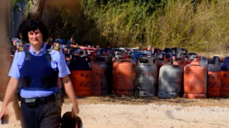 Policial espanhol ao lado de bujões de gás em Alcanar