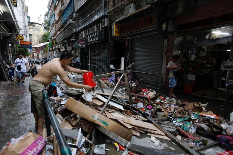 Homem limpa loja atingida pelo tufão Hato, em Macau 24/08/2017 REUTERS/Tyrone Siu