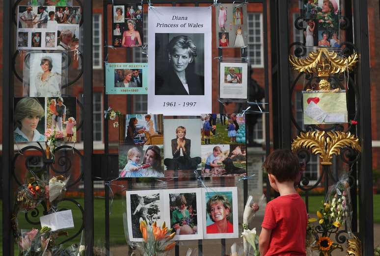Menino observa homenagem deixada para princesa Diana nos portões do palácio de Kensington, em Londres REUTERS/Hannah McKay
