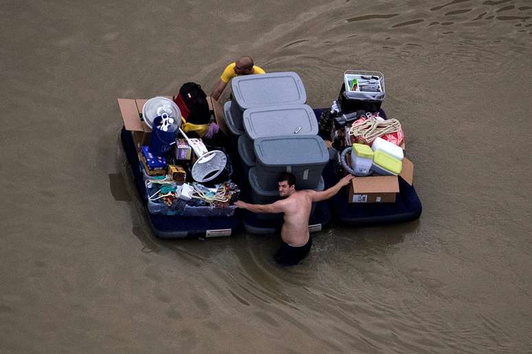 Moradores de Houston transportam seus pertences por ruas alagadas da cidade