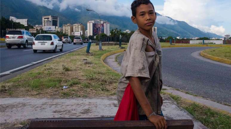 Nanye, de 12 anos, na entrada de uma galeria subterrânea que usa como esconderijo em uma das áreas mais movimentadas de Caracas