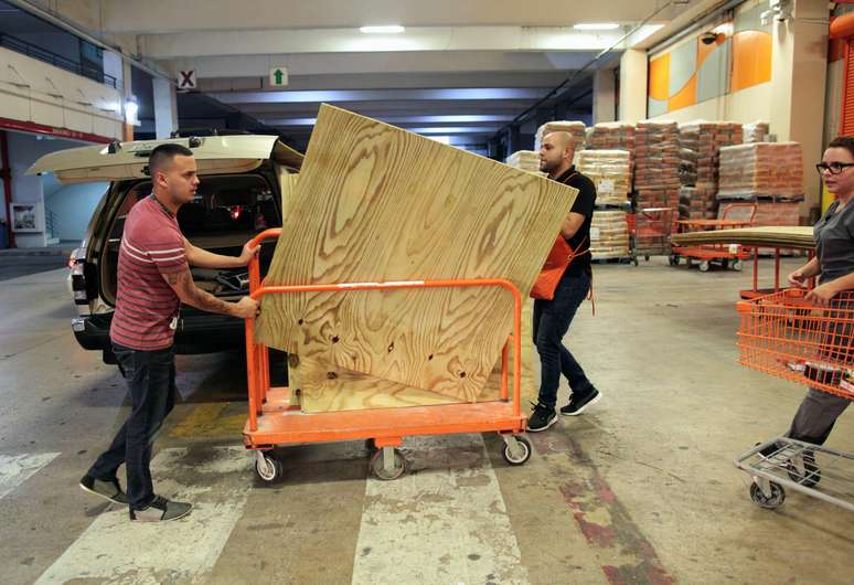 Habitantes de Porto Rico em loja de materiais de construção compram madeiramento para proteger suas casas