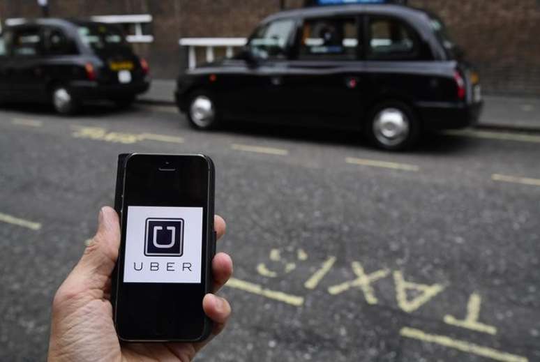 Aplicativo do Uber em celular diante de táxis em Londres, Reino Unido
28/11/2016 REUTERS/Toby Melville/Illustration