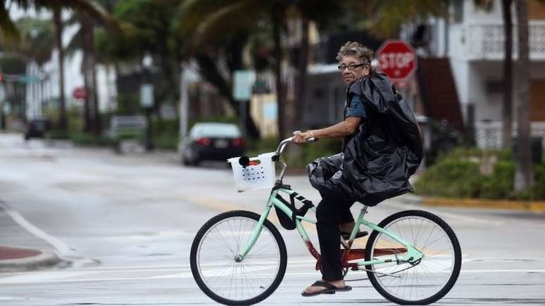 Homem anda de bicicleta por Miami Beach