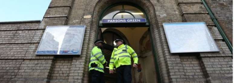 Dois policiais em frente à porta da estação de metrô Parsons Green