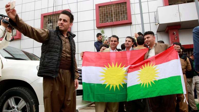 Curdos posam com sua bandeira