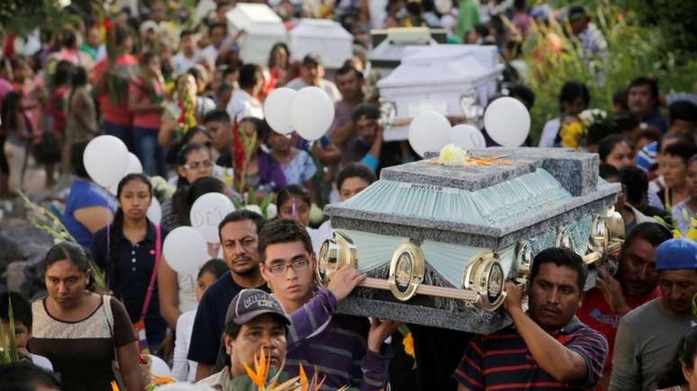 Depois da tragédia na igreja, familiares e amigos da família realizam um enterro coletivo na cidade 