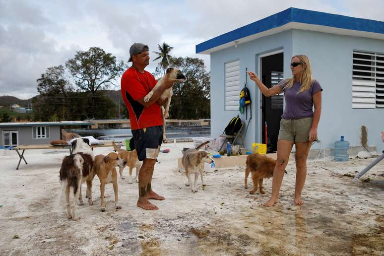 Sandra Harasimowicz conversa com seu marido, enquanto ele carrega um de seus cachorros no telhado da casa de um vizinho, depois que Porto Rico foi atingido pelo furacão Maria  25/09/2017 REUTERS/Carlos Garcia Rawlins