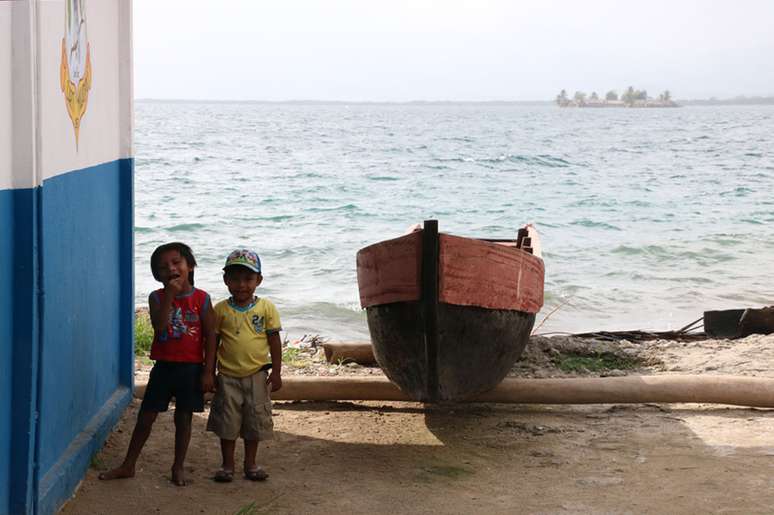Crianças gunas junto a uma canoa