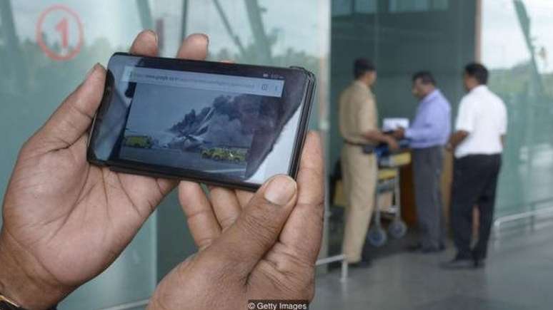 Celular mostrando acidente de avi&atilde;o