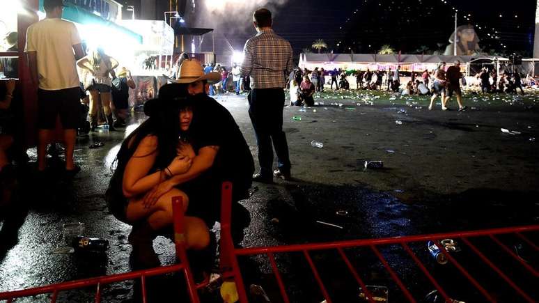 Casal se abraça no local do show onde atirador foi ouvido abrindo fogo. 