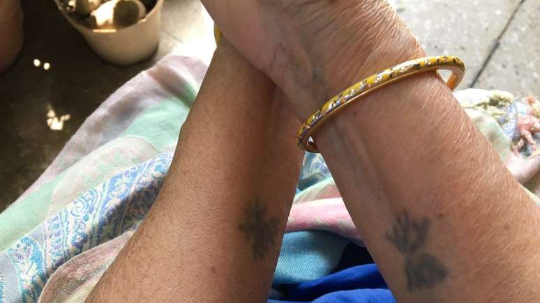 M&atilde;e olha para suas tatuagens