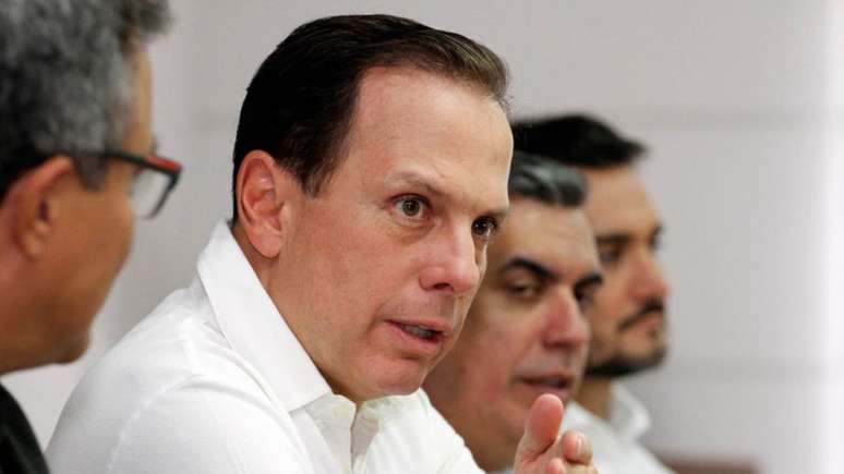 João Doria discursa em uma mesa com empresários