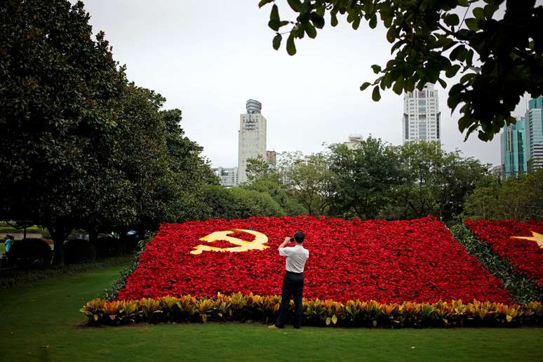 Um homem tira fotos da bandeira do Partido Comunista da China feita com flores  em Xangai, China


30/09/2017     REUTERS/Aly Song