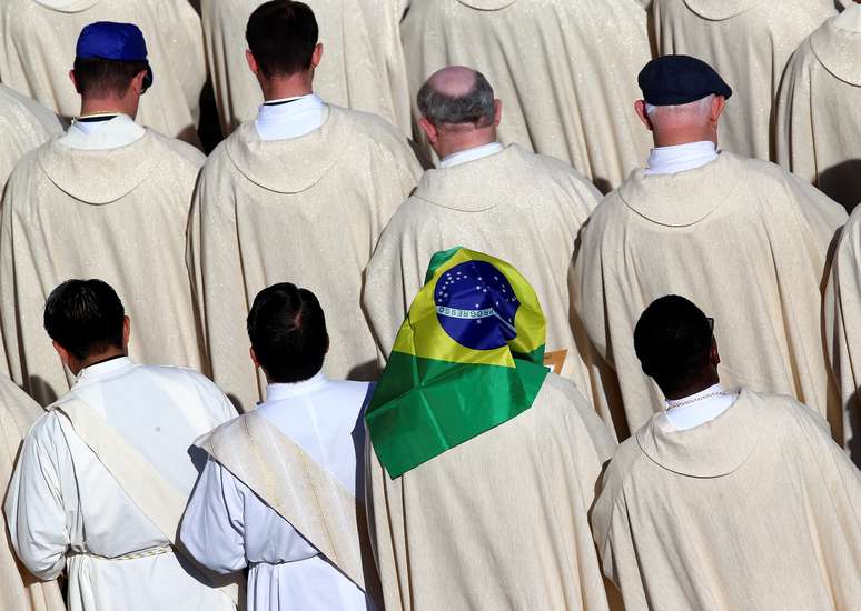 Sacerdote é visto com uma bandeira brasileira durante miss em que o papa Francis canonizou grupo de brasileiros