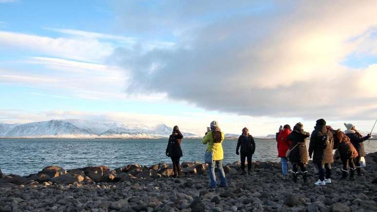 Turistas posam diante de geleira em Reykjavík