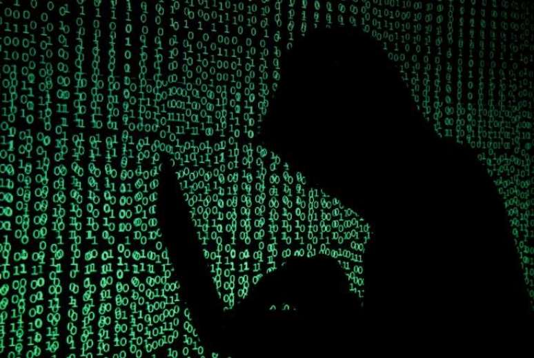 Pessoa usa computador diante de projeção de códigos cibernéticos
13/05/2017 REUTERS/Kacper Pempel/Illustration