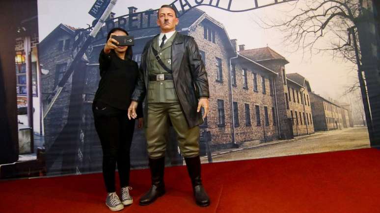 Mulher posa com estátua de Hitler