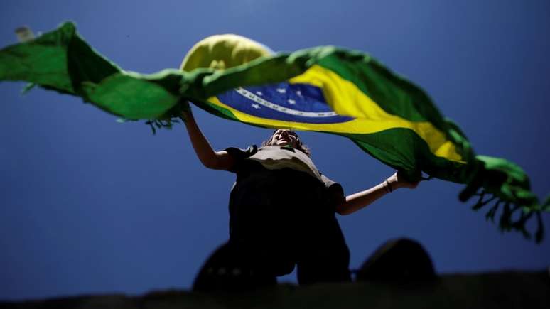 Mulher segura bandeira do Brasil