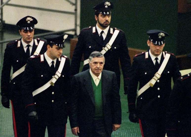 Imagem do chefe da m&aacute;fia Siciliana do s&eacute;culo 20, Salvatore "Toto" Riina, sendo escoltado por agentes italianos em Palermo, na It&aacute;lia, em 1&deg; de dezembro de 1993
