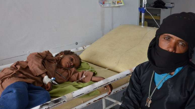 Mãe ao lado do filho que se recuperava de cólera na cidade de Khamer