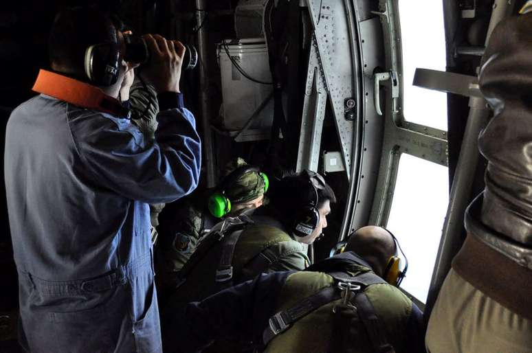 Membros da marinha argentina olham para o mar a partir de um avião durante um vôo para procurar o submarino ARA San Juan desaparecido no marMembros da marinha argentina olham para o mar a partir de um avião durante um voo para procurar o submarino Argentino ARA San Juan, que sumiu no mar