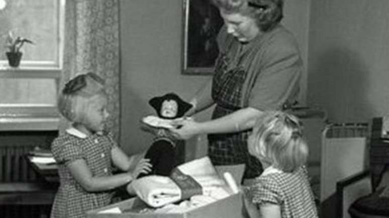 Mãe mostra conteúdo da caixa às filhas, em foto de 1947; item é uma importante política social finlandesa | Foto: Museu do Trabalho da Finlândia Werstas