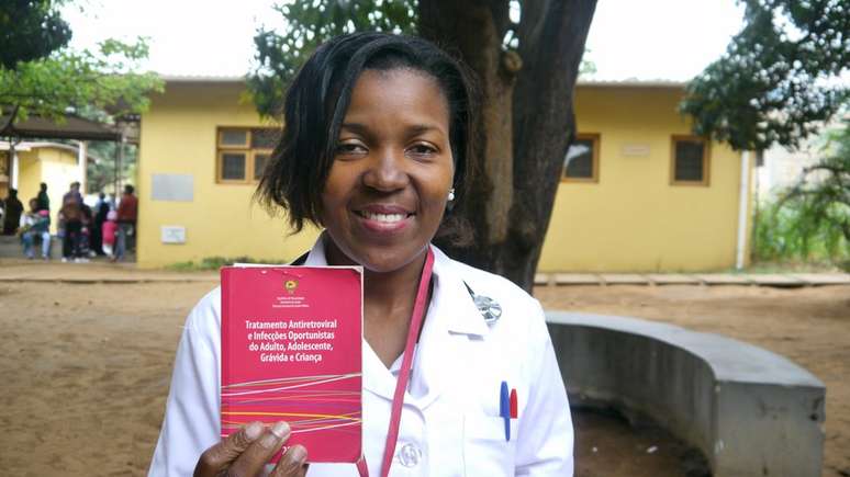 Técnica de medicina Cecília José Sitoe mostra guia moçambicano que lista terapias usadas contra HIV no país | Foto: Amanda Rossi/BBC Brasil
