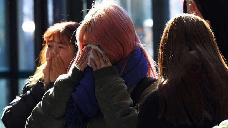 Fãs de Kim Jong-hyun prestam homenagens no hospital | foto: YEON-JE/AFP/Getty Images