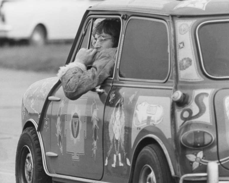 Dois ícones britânicos: John Lennon no mini de George Harrison em um pequeno aeroporto ao sul de Londres onde os Beatles estavam filmando 'Magical Mystery Tour', em 1967