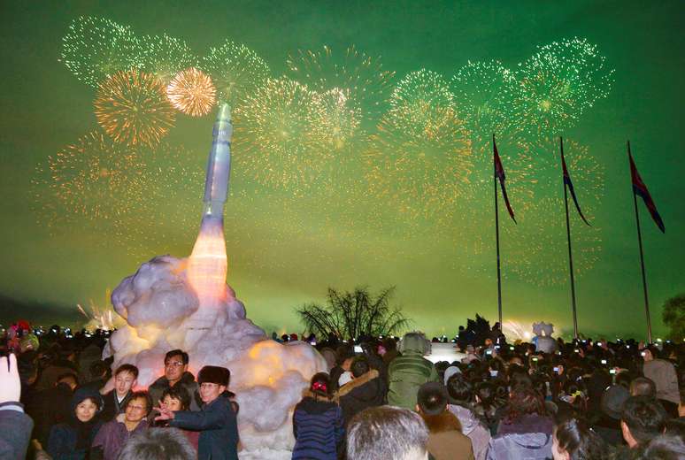 Coreanos comemoram o Réveillon em frente a uma estátua de gelo do míssil balístico intercontinental em Pyongyang, na Coréia do Norte