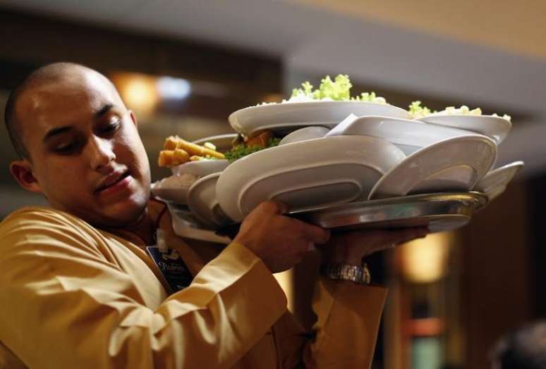 Gar&ccedil;om carrega bandeja de pratos em restaurante de Porto Alegre, Rio Grande do Sul 18/06/2014 REUTERS/Marko Djurica