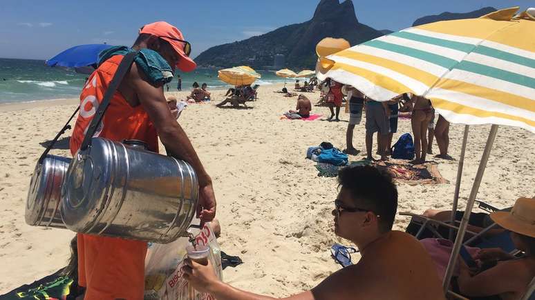 Cada copo de mate custa R$ 5; Fabiano diz que já saiu da praia com apenas R$ 15 em um dia ruim de vendas | Foto: Ana Terra Athayde/BBC