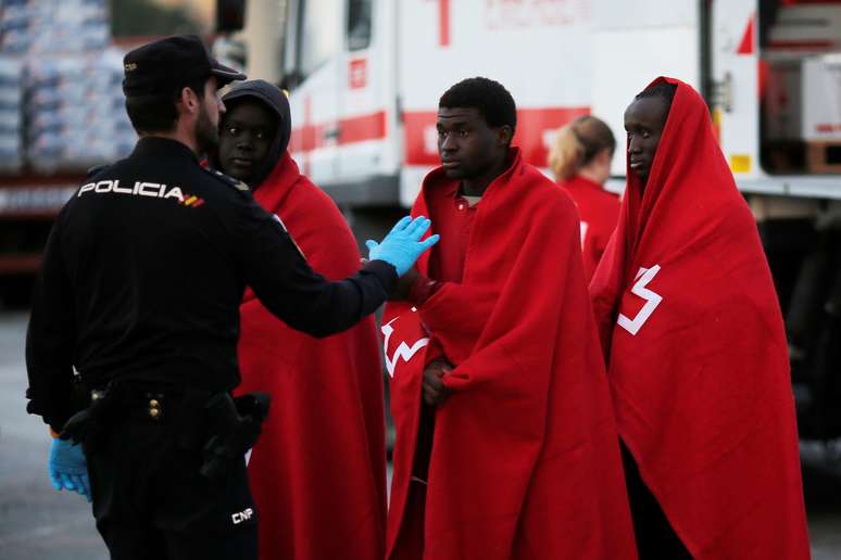 Imigrantes são conduzidos por policial espanhol em Málaga, na Espanha 13/01/2018 REUTERS/Jon Nazca