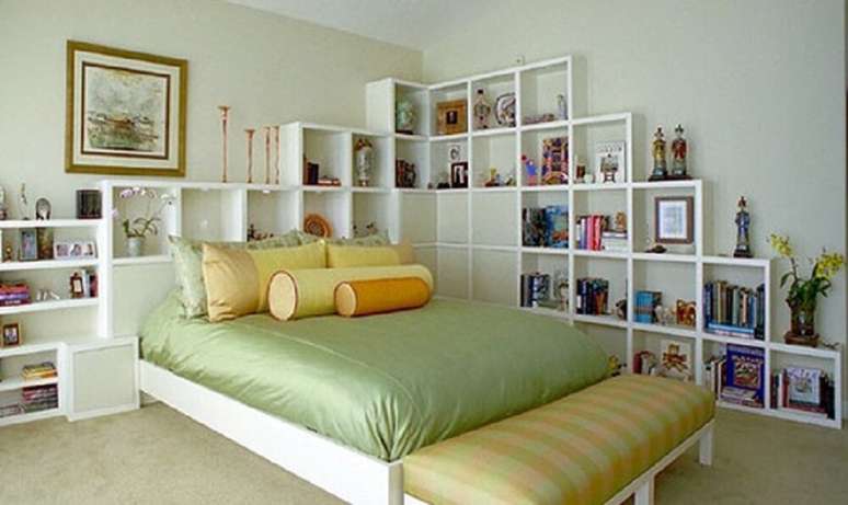 29. Quarto decorado em tons de amarelo e ver, com muitas prateleiras.