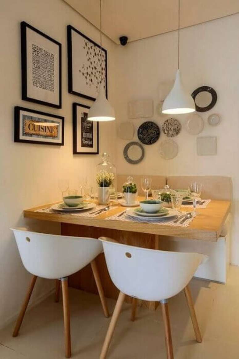 30. Sala de jantar bem pequena e aconchegante com quadros na parede