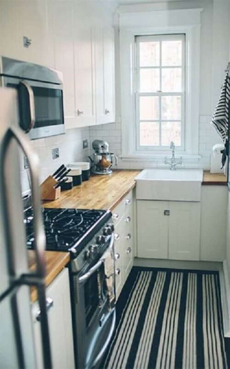 39. O tapete com listras podem dar a impressão de uma cozinha pequena maior visualmente